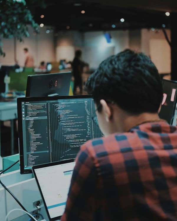 A developer at his screens, reading code.