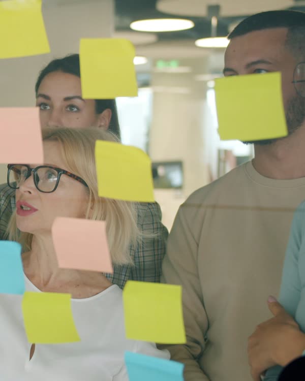 A team planning a campaign with notes on a glass wall.