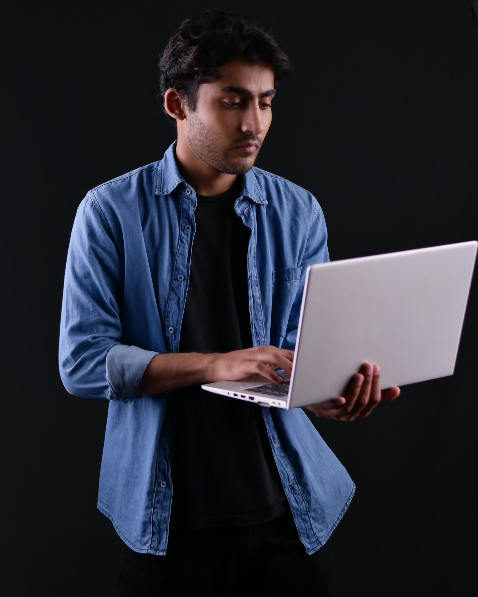 A first-year student at work in the studio, the Sierra pin on their shirt pocket.